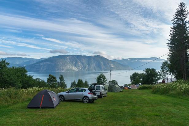 Fjord camping area with cars and tents Fjord camping area with cars and tents