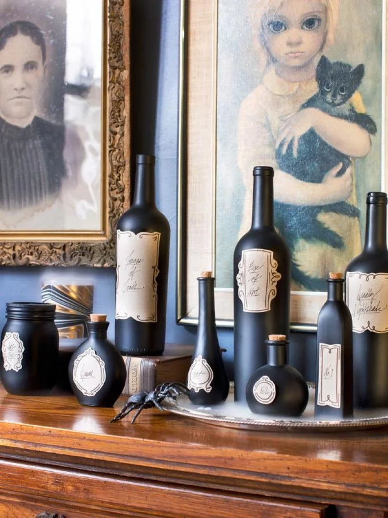 Before you toss that empty glass bottle, think of it more as Halloween decor than trash! Collect empty glass bottles throughout the year, concentrating on those with different shapes, sizes and heights. In a well-ventilated area, add two thorough coats of flat black spray paint, keeping the can held 6 to 8 inches from the surface of the bottles steadily moving back and forth with quick spurts. Download original label templates on HGTV.com, print them out on label paper, then stick to the painted bottles and label appropriately.